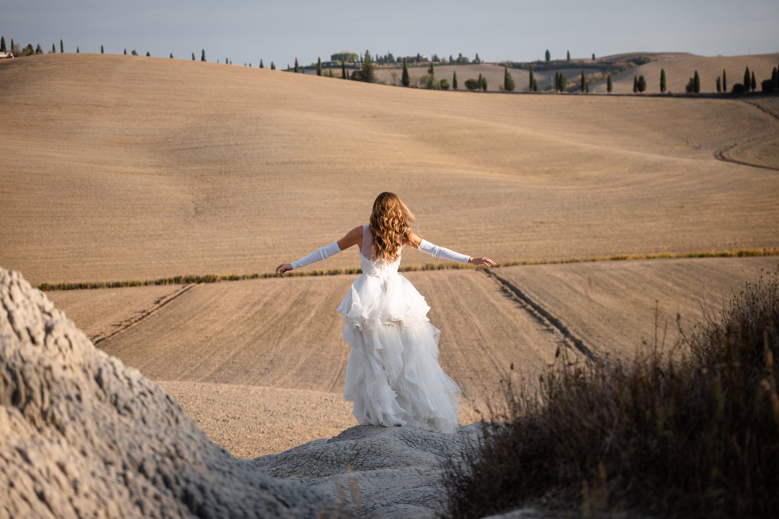 Bride in wedding dress walking in the Tuscan countryside